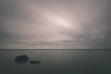 uzun pozlama deniz kaya ile plaj ve su dalgalar yıkanmış. vintage eski film dokulu soyut resim - bak