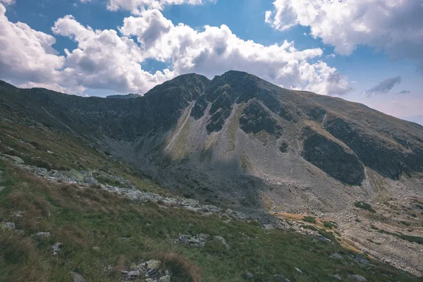 beautiful rocky mountain tops with hiking trails in autumn in Slovakian Tatra western Carpathian mountains with blue sky and late grass on hills. Empty rocks in bright daylight, far horizon for adventures