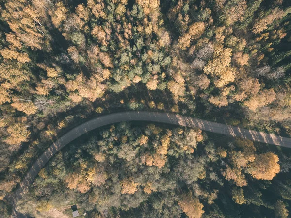 drone image. aerial view of rural area with gravel road in autumn colored fields and forests. latvia - vintage old film look