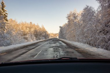 kırsal kış günbatımı üzerinde tekerlek iziyle kar ve buz kaplı yolda