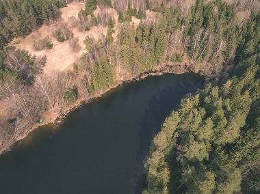 drone görüntü. alanları ve ormanları ve bulutlu bahar günü nehir su yansımalar kırsal alan hava görünümünü. Letonya - vintage eski film bakmak