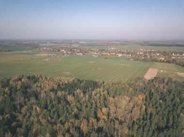 drone görüntü. hava alanları ve sarı renkli bulutlu sonbahar günü ormanlarda kırsal alan görünümünü ağaçlar gün düşer. Letonya - vintage eski film bakmak