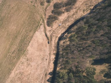 drone görüntü. alanları ve ormanları ve bulutlu bahar günü nehir su yansımalar kırsal alan hava görünümünü. Letonya - vintage eski film bakmak