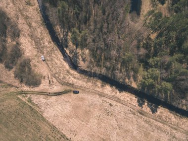 drone görüntü. alanları ve ormanları ve bulutlu bahar günü nehir su yansımalar kırsal alan hava görünümünü. Letonya - vintage eski film bakmak