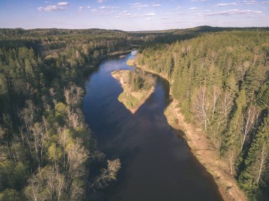 drone görüntü. alanları ve ormanları ve bulutlu bahar günü nehir su yansımalar kırsal alan hava görünümünü. Letonya - vintage eski film bakmak