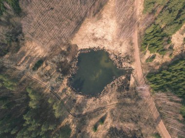 drone görüntü. alanları ve ormanları ve bulutlu bahar günü nehir su yansımalar kırsal alan hava görünümünü. Letonya - vintage eski film bakmak