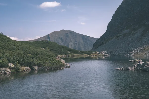 beautiful mountain lake panorama view in late summer in Slovakian Carpathian Tatra mountains with reflections of rocky hills in water. Rohacske plesa lakes near Zverovka village