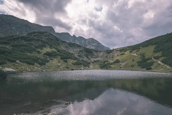 beautiful mountain lake panorama view in late summer in Slovakian Carpathian Tatra mountains with reflections of rocky hills in water. Rohacske plesa lakes near Zverovka village