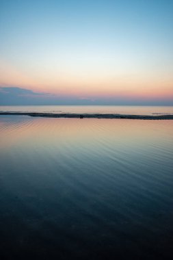 Baltık Denizi temiz su üzerinde sakin mavi günbatımı. düz ufuk çizgisi ve dalgalar su doku ile minimalist görüntü