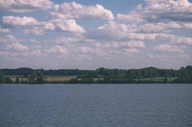 panoramik deniz plaj manzarası içinde kaya, bitkiler ve temiz su ile yaz aylarında güneşli bir gün