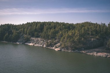 kayalık sahil şeridine Finlandiya'da birkaç çam ağaçları ve yaz - vintage bir retro görünüm sakin suda