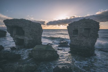 tuğla ve beton yapıların eski savaş fort ayrıntıları ile su dalgalar deniz Dramaturji günbatımında yıkadı. Liepaja, Letonya 