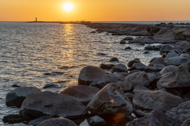 dalgakıran deniz günbatımı insanlar tarafından yürüyüş sonunda kırmızı deniz feneri ile