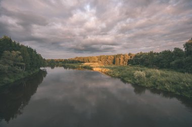 renkli sunset Bulvarında Göl su yansımaları ve dramatik fırtına bulutları yukarıdaki ile. geç akşam renkler - vintage bir retro görünüm