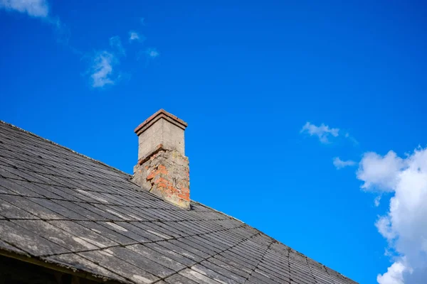 country house roof top with chimney on blue sky background