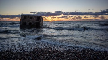 tuğla ve beton yapıların eski savaş fort ayrıntıları ile su dalgalar deniz Dramaturji günbatımında yıkadı. Liepaja, Letonya 