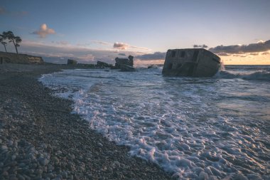 tuğla ve beton yapıların eski savaş fort ayrıntıları ile su dalgalar deniz Dramaturji günbatımında yıkadı. Liepaja, Letonya 