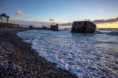 tuğla ve beton yapıların eski savaş fort ayrıntıları ile su dalgalar deniz Dramaturji günbatımında yıkadı. Liepaja, Letonya 