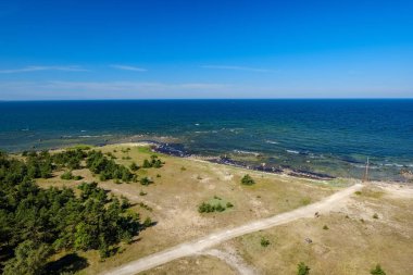 panoramik deniz plaj manzarası içinde kaya, bitkiler ve temiz su ile yaz aylarında güneşli bir gün