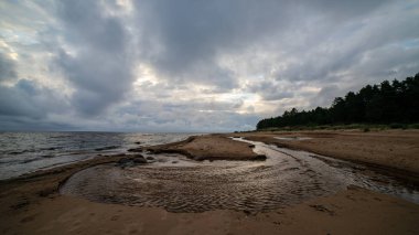 fırtına bulutları içinde şekillendirme deniz plaj kayalar ile temizleyin ve kum temizleyin. dramatik renkleri