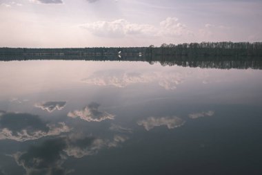 doğal vücut su. Gölet yansımaları, ağaç ve sakin su yüzeyi - vintage bir retro görünüm bulutlarda ile.