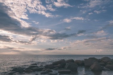 bulutlar ve sakin su ile deniz plaj manzarası. renkli sahne - vintage retro bak