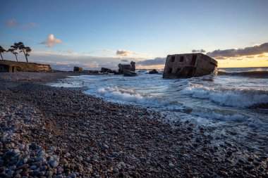 tuğla ve beton yapıların eski savaş fort ayrıntıları ile su dalgalar deniz Dramaturji günbatımında yıkadı. Liepaja, Letonya