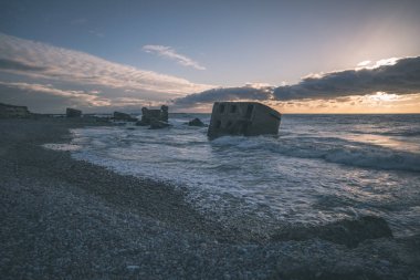tuğla ve beton yapıların eski savaş fort ayrıntıları ile su dalgalar deniz Dramaturji günbatımında yıkadı. Liepaja, Letonya - vintage bir retro görünüm