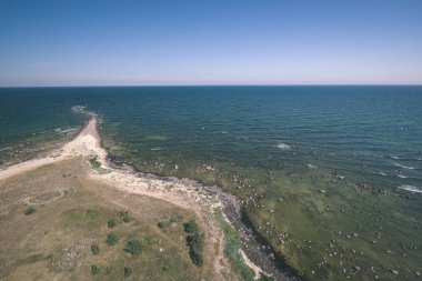 panoramik deniz plaj kayalar, bitkiler ve temiz su ile yaz aylarında güneşli gün - vintage bir retro görünüm görünümünde