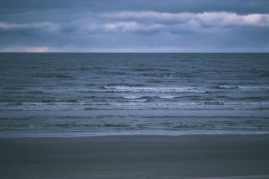 deniz üzerinde fırtına bulutları. temiz beyaz kum plaj üzerinde küçük dalgalar. sığ derinlik-in tarla - vintage bir retro görünüm