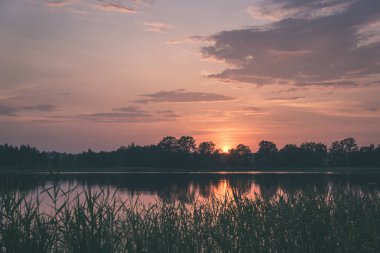renkli sunset Bulvarında Göl su yansımaları ve dramatik fırtına bulutları yukarıdaki ile. geç akşam renkler - vintage bir retro görünüm