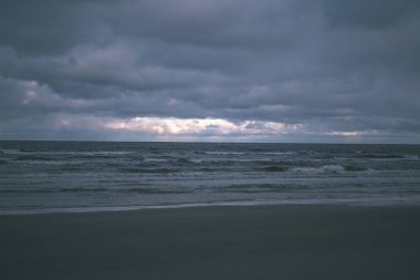 deniz üzerinde fırtına bulutları. temiz beyaz kum plaj üzerinde küçük dalgalar. sığ derinlik-in tarla 