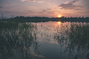 renkli sunset Bulvarında Göl su yansımaları ve dramatik fırtına bulutları yukarıdaki ile. geç akşam renkler - vintage bir retro görünüm
