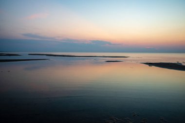 Baltık Denizi temiz su üzerinde sakin mavi günbatımı. düz ufuk çizgisi ve dalgalar su doku ile minimalist görüntü