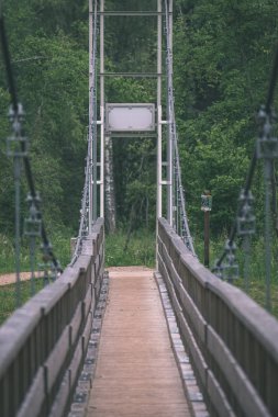 su yeşil yaz orman çevresinde göl ile ahşap ve kompozit malzeme ayak köprüden