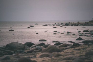 kayalık sahil şeridine Letonya akış su deniz ve geç sonbaharda büyük kayalar. mat renkler - retro vintage bak