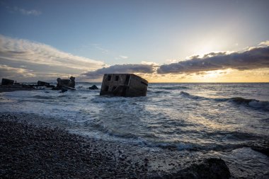 tuğla ve beton yapıların eski savaş fort ayrıntıları ile su dalgalar deniz Dramaturji günbatımında yıkadı. Liepaja, Letonya 
