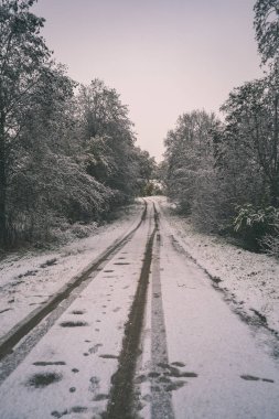 kırsal kış lastik izleri - vintage bir retro görünüm ile kar ve buz kaplı yolda