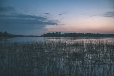 renkli sunset Bulvarında Göl su yansımaları ve dramatik fırtına bulutları yukarıdaki ile. geç akşam renkler - vintage bir retro görünüm