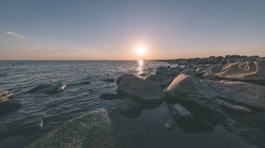 panoramik deniz plaj kayalar, bitkiler ve temiz su ile yaz aylarında güneşli gün - vintage bir retro görünüm görünümünde