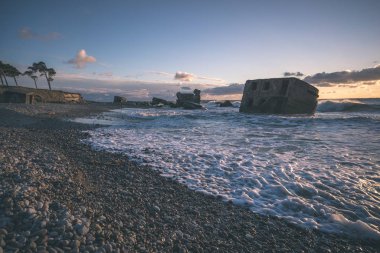 tuğla ve beton yapıların eski savaş fort ayrıntıları ile su dalgalar deniz Dramaturji günbatımında yıkadı. Liepaja, Letonya - vintage bir retro görünüm