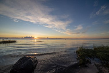 boş deniz plaj kum tepeleri ve kuru ağaç gövdeleri kıyıya yaz aylarında yıkadım. sakin su