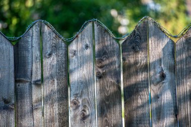Yaz aylarında eski ahşap çit üstünde paslı dikenli tel