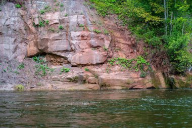 güzel kumtaşı kayalıklarla ve woods Amata Letonya sakin Nehri'nin kıyısında