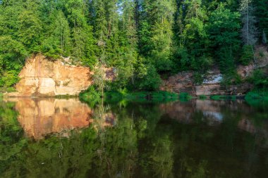 güzel kumtaşı kayalıklarla ve woods Amata Letonya sakin Nehri'nin kıyısında