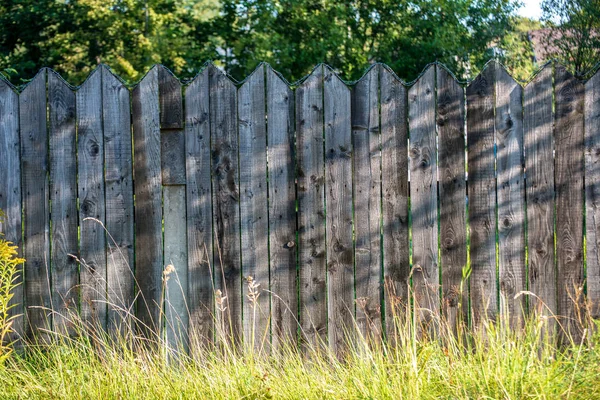 夏季には緑の葉の古い木製フェンスの上に錆びた有刺鉄線 — ストック写真