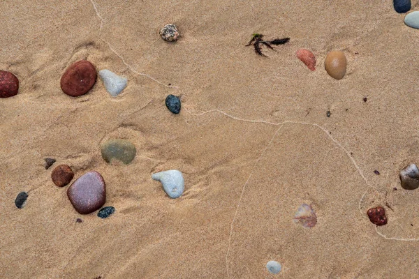 colorful pebbles scattered on sand surface on beah