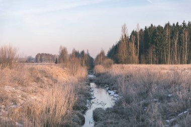 Kış güneşli kırsal kesimde akan dere