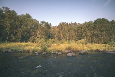 nehir, Amata Letonya ile kumtaşı kayalıklarla, yeşil yapraklar yaz aylarında su akışı
