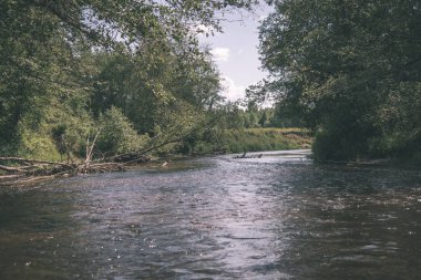 nehir, Amata Letonya ile kumtaşı kayalıklarla, yeşil yapraklar yaz aylarında su akışı